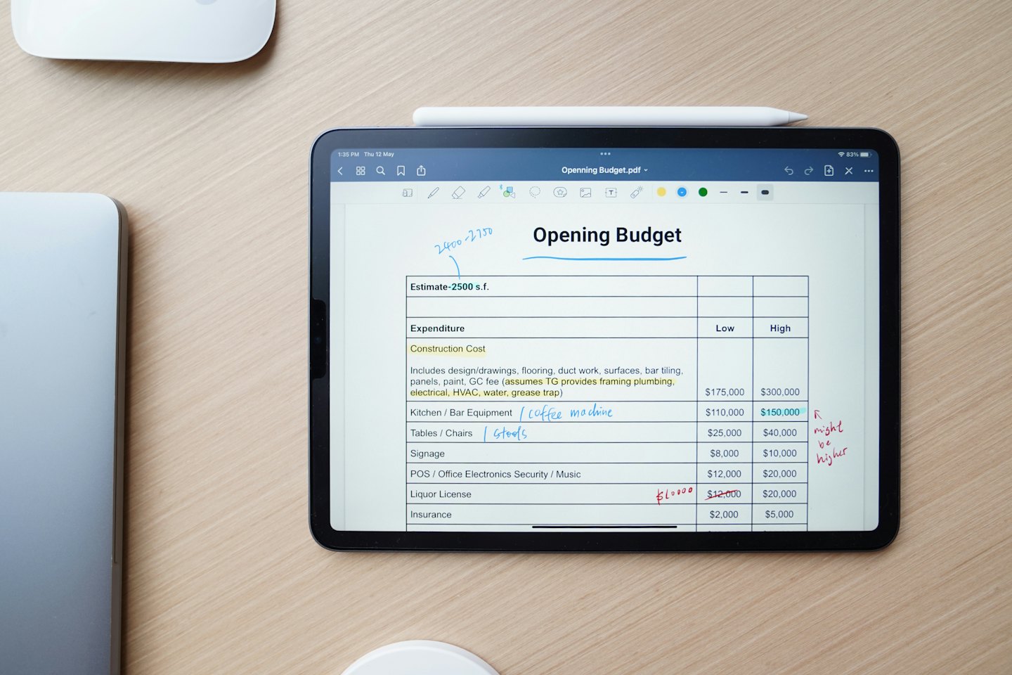 Tablette affichant un budget financier sur un bureau en bois.
