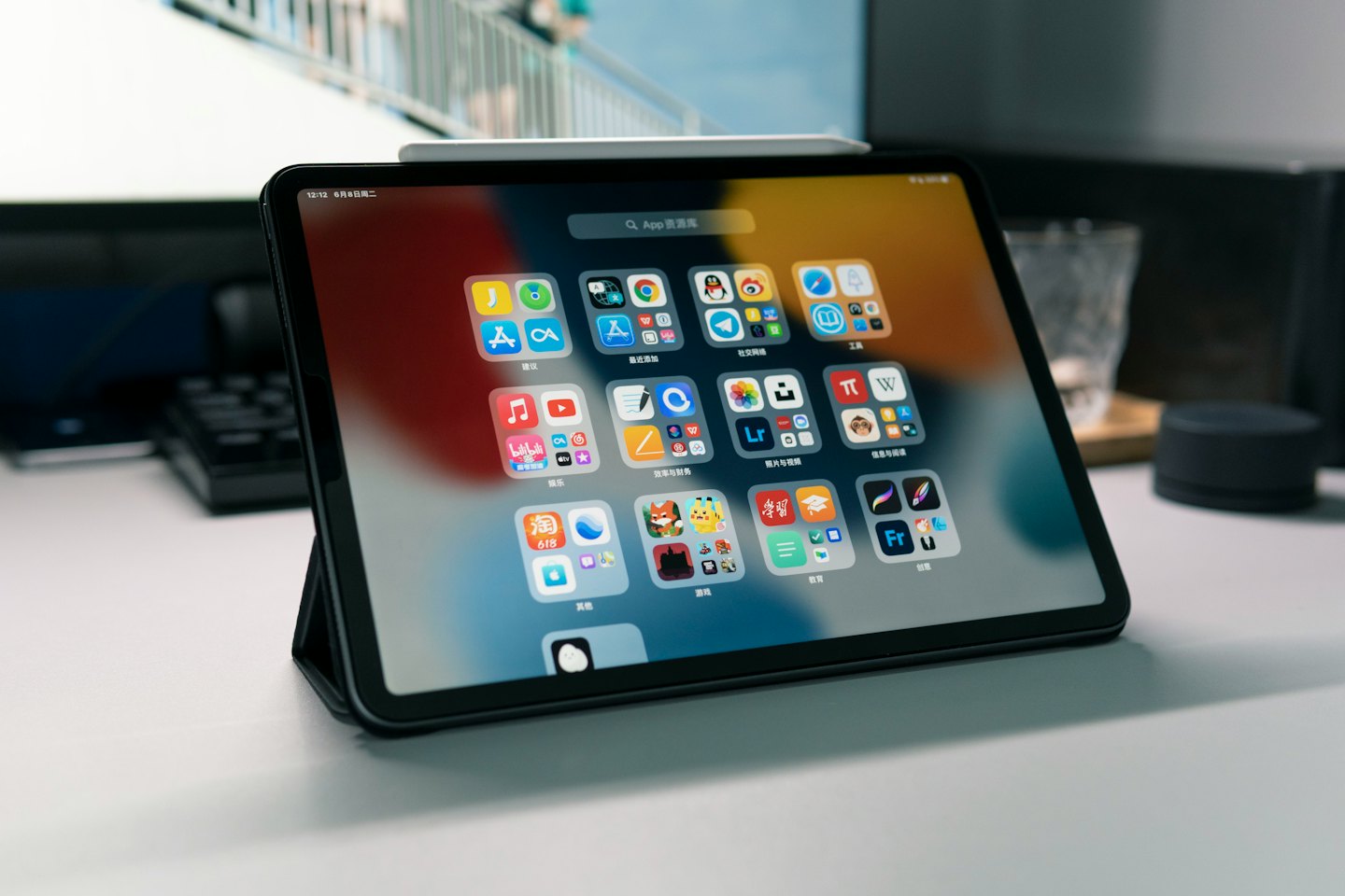 Une tablette avec des icônes d’applications colorées repose sur un bureau blanc.