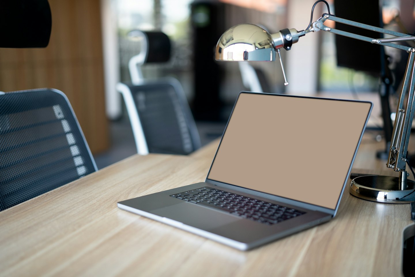 Un ordinateur portable moderne posé sur un bureau en bois clair.