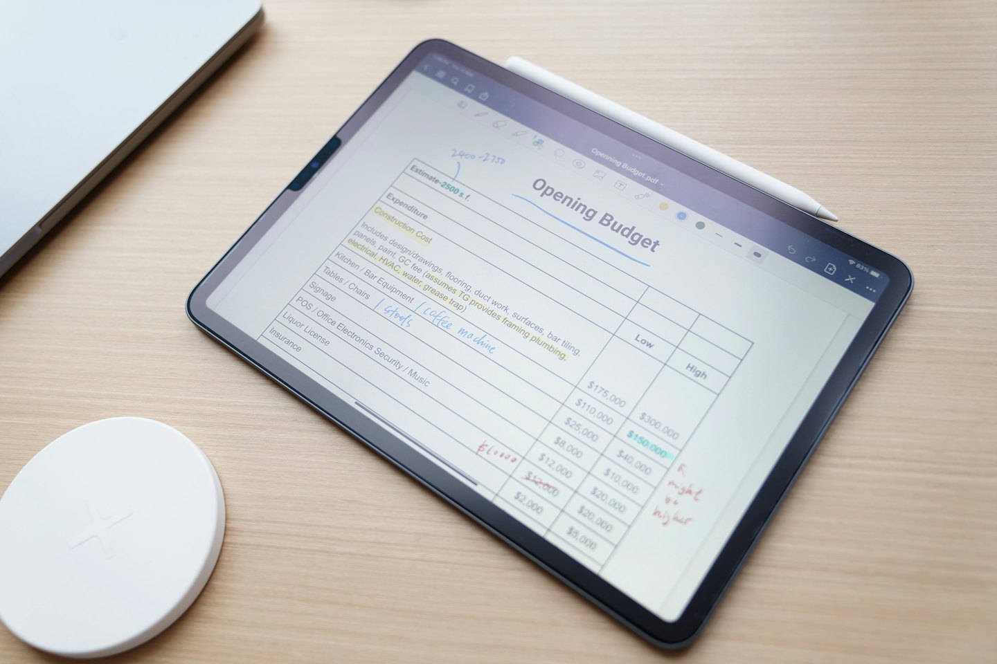 Tablette affichant une feuille de calcul budgétaire numérique avec un stylet à l'écran.