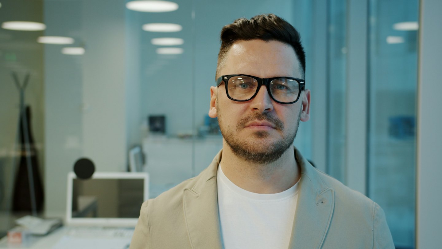 Homme professionnel en blazer travaillant dans un bureau moderne.