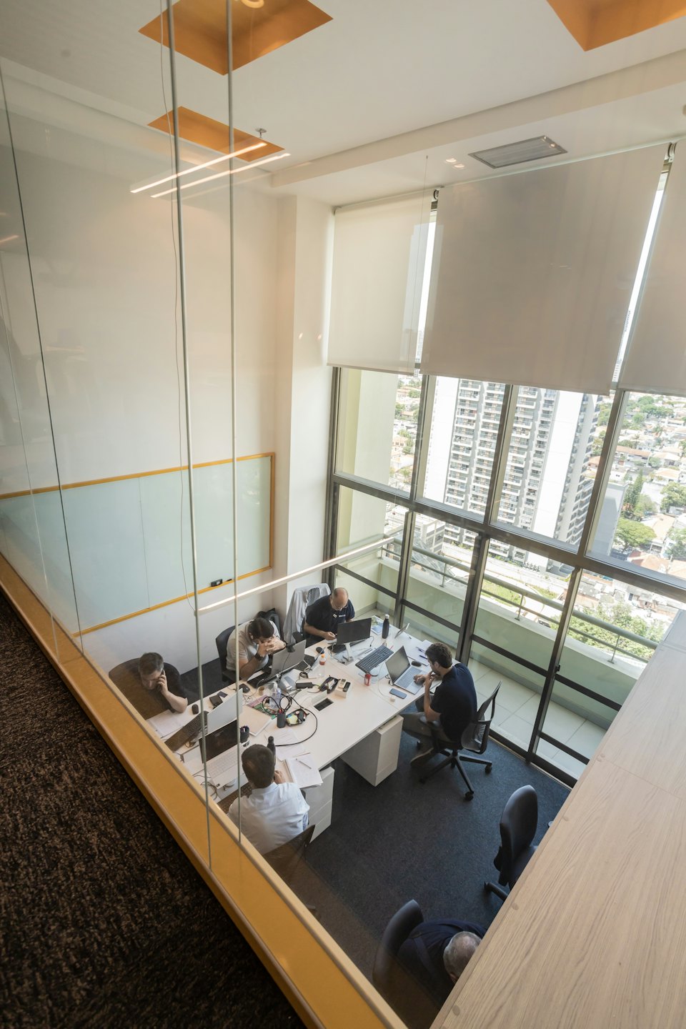 Des professionnels collaborant dans un bureau décloisonné lumineux et moderne.
