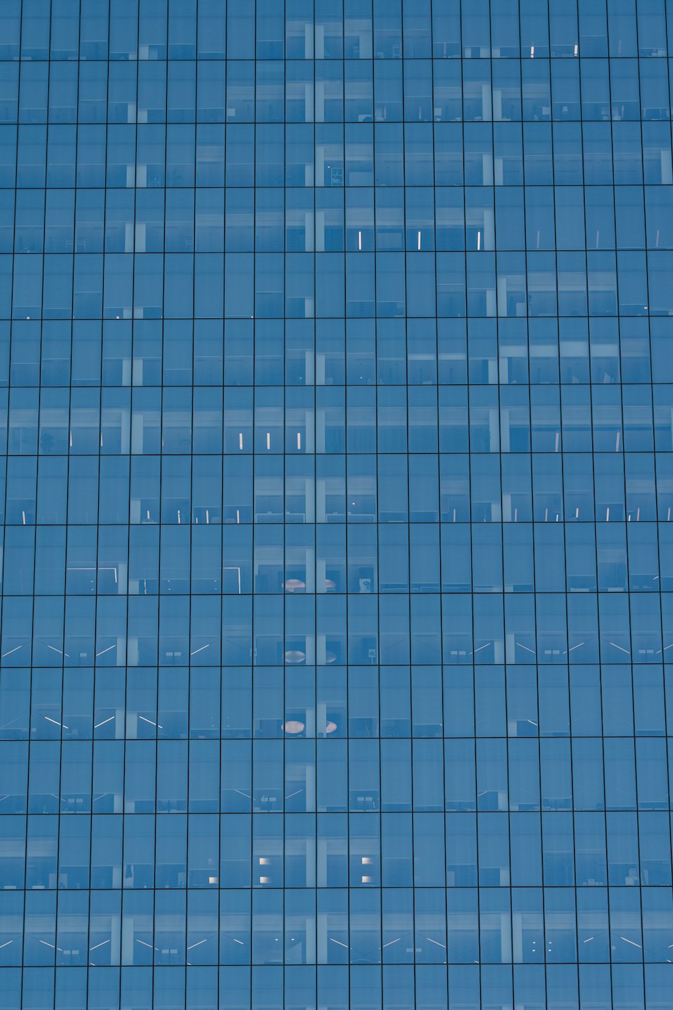 Immeuble de bureaux moderne avec une façade en grille de verre réfléchissant.
