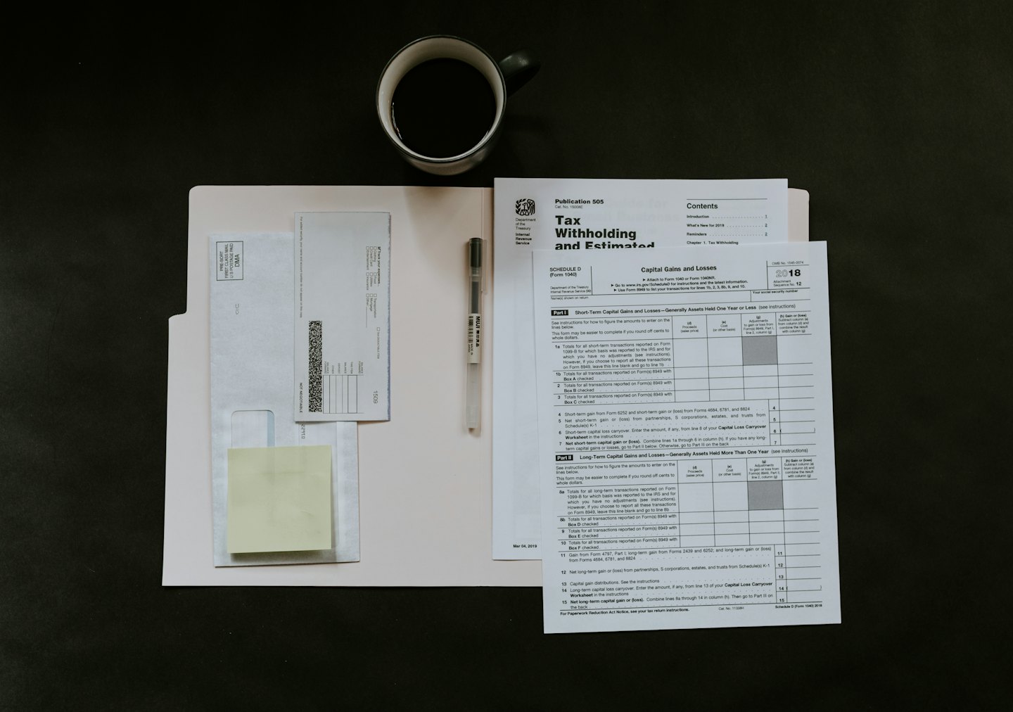 Formulaires fiscaux et tasse de café sur un bureau.